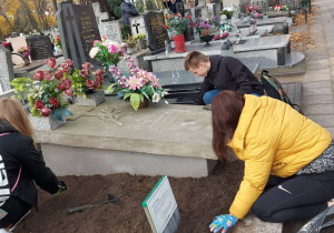 Młodzież podczas porządkowania grobów