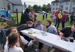 Wolontariuszki SK Caritas malują dzieci uczestniczące w pikniku