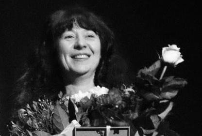 Nauczycielka Izabela Szymańska trzymająca kwiaty na scenie teatru