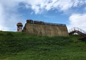 Uczestnicy wycieczki w Beskid Niski na murze obronnym w skansenie