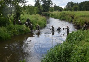Uczestnicy przeprawiają się przez rzekę Wolbórkę