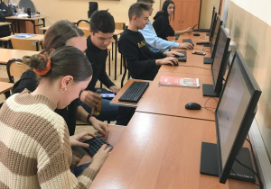 Uczestnicy projektu FERS Technikum Architektury Krajobrazu podczas kursu przygotowania językowego siedzą w ławkach przy komputerach w pracowni 02