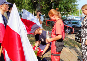 Uczniowie wraz z p. Katarzyną Pfau wicedyrektor szkoły składają kwiaty