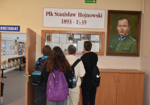 Uczniowie szkoły podstawowej pod gablotą poświęconą płk. S. Hojnowskiemu w ZSP nr 8