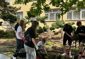 Uczniowie wykonują prace w ogrodzie