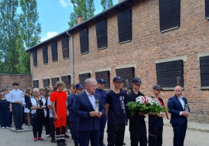 Uczestnicy składają kwiaty i znicze
