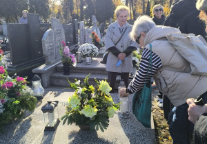 Emerytowani pracownicy wraz z uczniami zapalają znicze