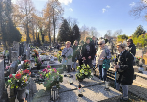 Emerytowani pracownicy wraz z uczniami zapalają znicze