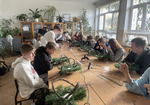 uczniowie kończący konstrukcję z gałązek pod wykonanie