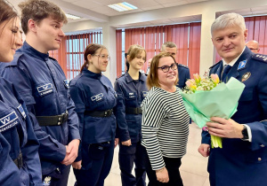 Dyrekcja , uczniowie wręczają kwiaty p. insp. Tomaszowi Jędrzejczykowi