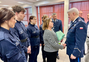 Dyrekcja , uczniowie wręczają kwiaty p. insp. Tomaszowi Jędrzejczykowi