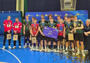 Siatkarze pozujący do pamiątkowego zdjęcia po wygraniu turnieju wojewódzkiego