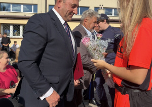 Uczniowie wręczają kwiaty Staroście Powiatu Tomaszowskiego p.Dariuszowi Kowalczykowi